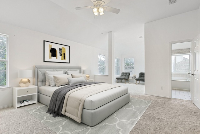 bedroom with light carpet, multiple windows, and ensuite bathroom