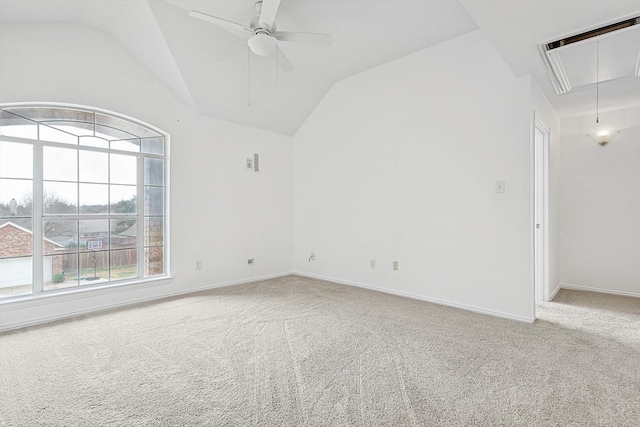 unfurnished room featuring carpet floors, a ceiling fan, baseboards, vaulted ceiling, and attic access