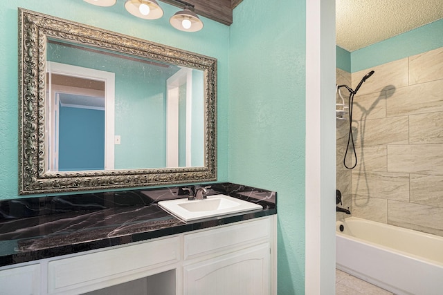 bathroom with shower / washtub combination, a textured wall, and vanity