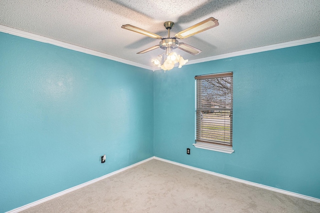carpeted spare room featuring a textured ceiling, a ceiling fan, ornamental molding, and baseboards