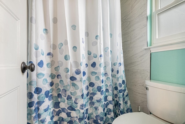 bathroom featuring toilet and a shower with shower curtain