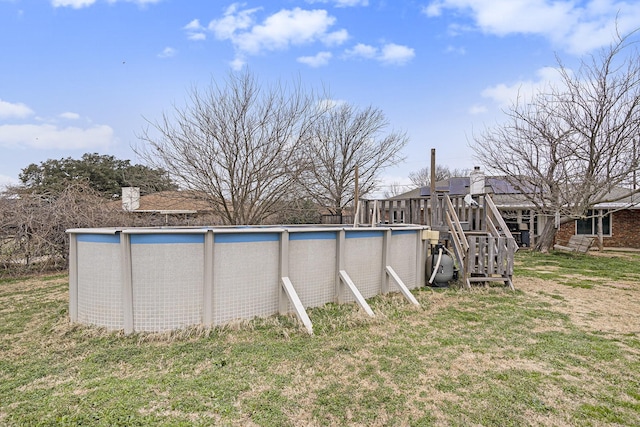 outdoor pool featuring a yard