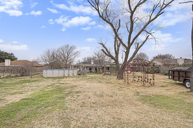 view of yard with fence and an outdoor pool