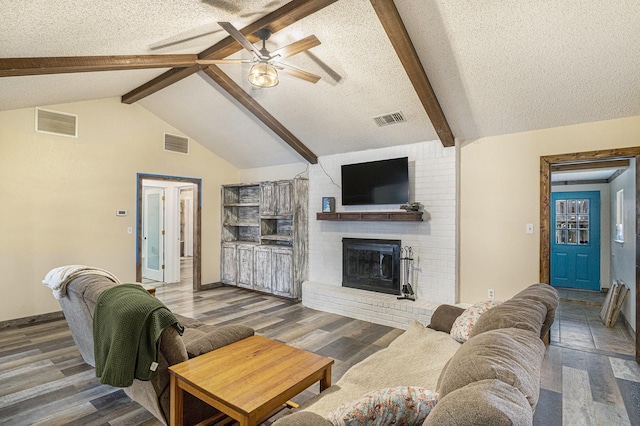 living area featuring visible vents, a ceiling fan, and a textured ceiling