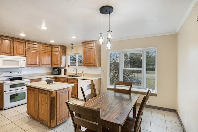 kitchen with brown cabinets, light tile patterned flooring, white appliances, crown molding, and light countertops