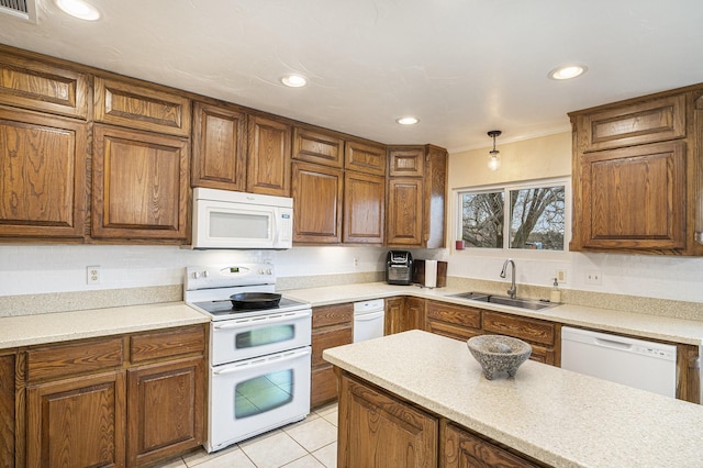 kitchen featuring a sink, brown cabinets, white appliances, visible vents, and light countertops