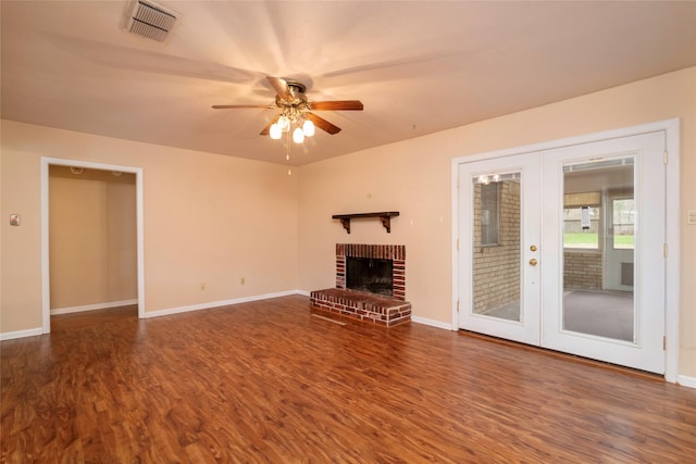 unfurnished living room featuring french doors, ceiling fan, a brick fireplace, and hardwood / wood-style flooring