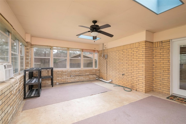 unfurnished sunroom featuring ceiling fan, plenty of natural light, and a skylight