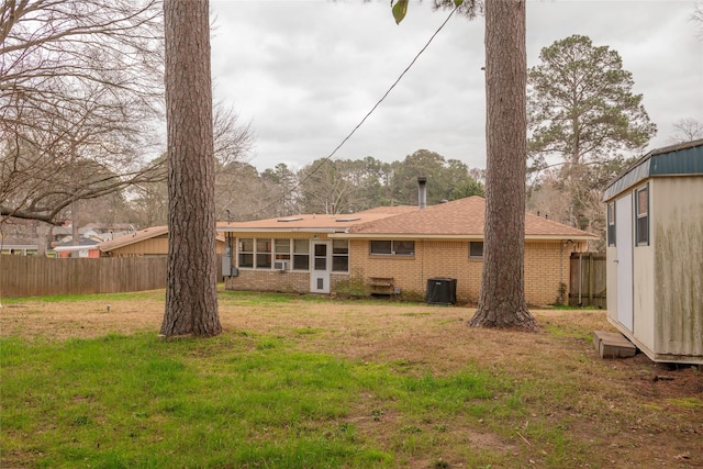 back of property with a yard and central AC