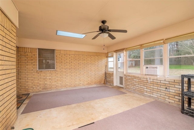 unfurnished sunroom with a skylight and ceiling fan