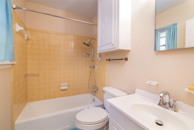 full bathroom featuring tiled shower / bath, vanity, and toilet