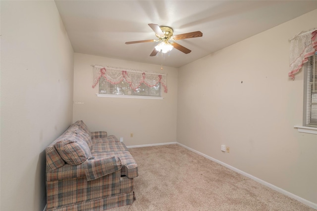 sitting room with ceiling fan and light colored carpet