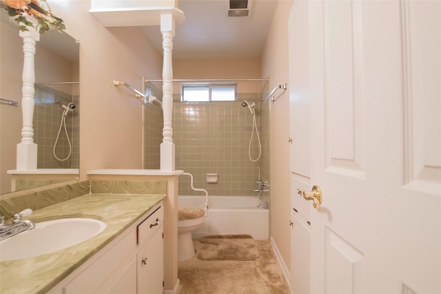 full bathroom featuring tiled shower / bath, vanity, and toilet