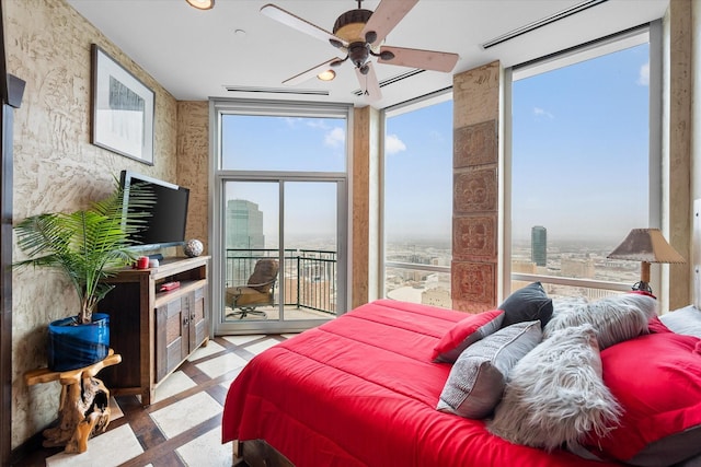 bedroom with expansive windows, access to exterior, and multiple windows