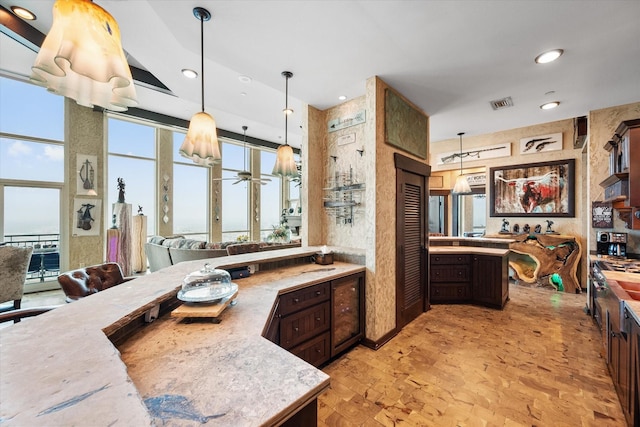 kitchen with pendant lighting, stainless steel range, and dark brown cabinetry