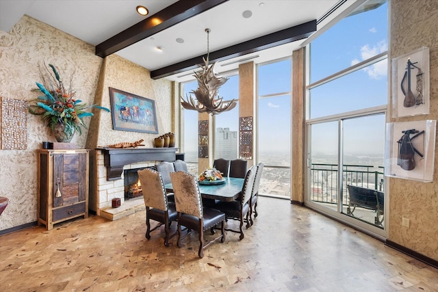 dining room featuring a fireplace, a water view, a wall of windows, beam ceiling, and a high ceiling