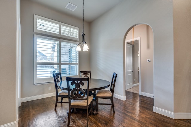 dining room with an inviting chandelier and dark wood-type flooring