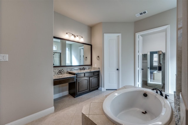 bathroom featuring vanity, tile patterned floors, and tiled bath