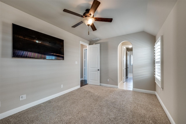 unfurnished bedroom featuring vaulted ceiling, light carpet, and ceiling fan