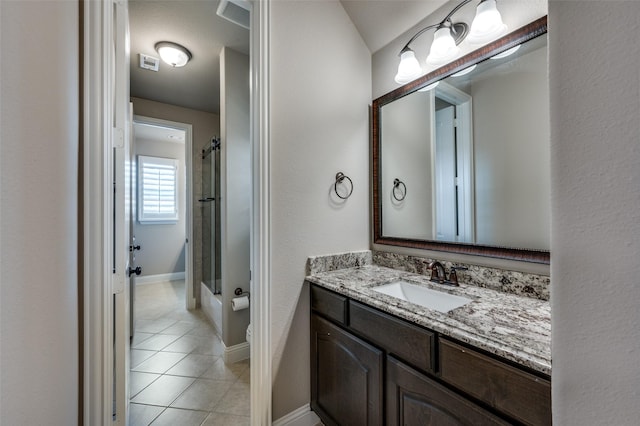 bathroom with tile patterned flooring, vanity, and walk in shower