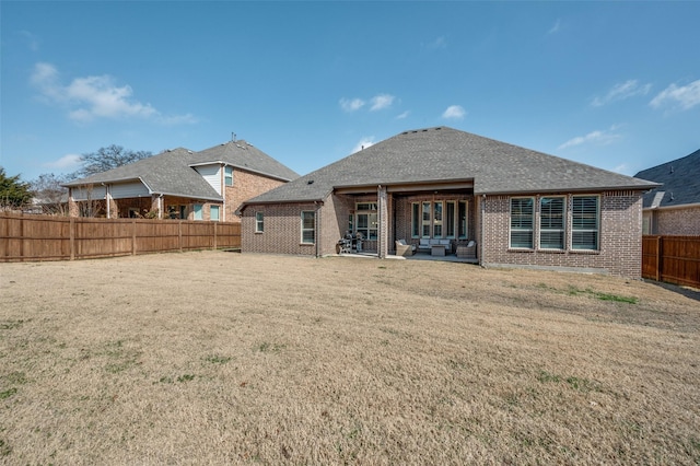 rear view of property featuring a lawn and a patio area