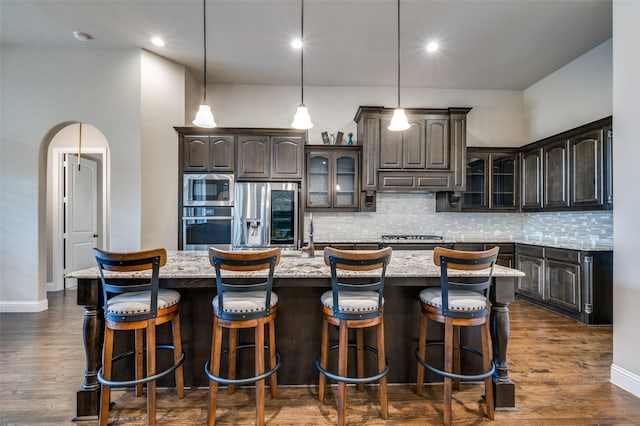 kitchen with a spacious island, dark brown cabinetry, and stainless steel appliances