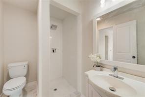 bathroom featuring sink, toilet, and walk in shower