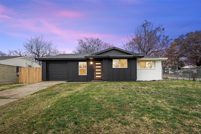 ranch-style house featuring a garage and a yard