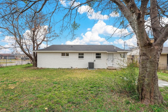 rear view of house featuring a yard and central AC