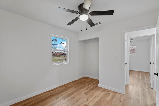 unfurnished bedroom with ceiling fan, light wood-type flooring, and a closet