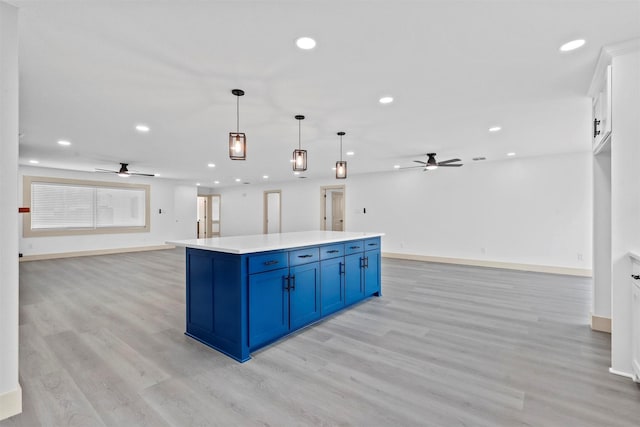 kitchen with white cabinets, open floor plan, light countertops, blue cabinetry, and pendant lighting