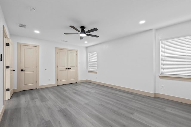 unfurnished bedroom featuring light wood-style flooring, recessed lighting, visible vents, baseboards, and multiple windows