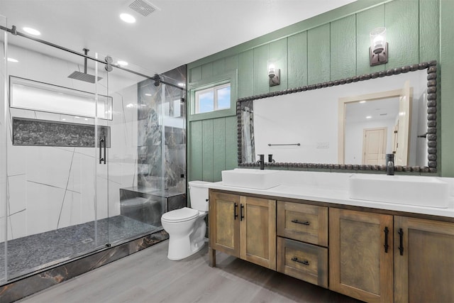 full bathroom featuring double vanity, a stall shower, visible vents, and a sink