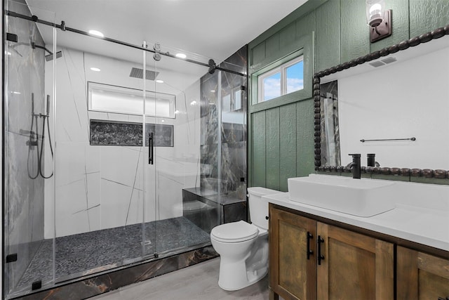 full bath with visible vents, toilet, a shower stall, and vanity