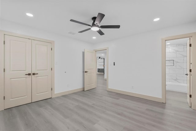 unfurnished bedroom featuring recessed lighting, a closet, ensuite bathroom, light wood-style floors, and baseboards