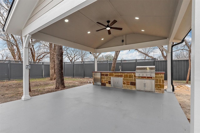 view of patio featuring a ceiling fan, a grill, a sink, exterior kitchen, and a fenced backyard