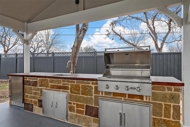 view of patio / terrace featuring a sink, grilling area, area for grilling, and fence