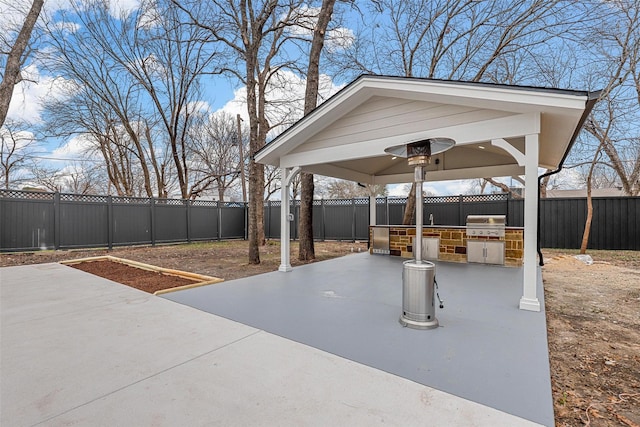 view of patio with a gazebo, a fenced backyard, a grill, and an outdoor kitchen