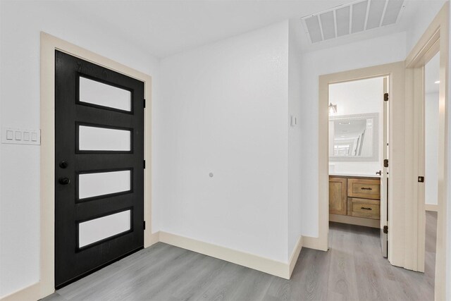 empty room featuring ceiling fan, light wood finished floors, visible vents, and baseboards