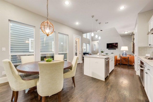 kitchen with dark wood-type flooring, appliances with stainless steel finishes, sink, and tasteful backsplash