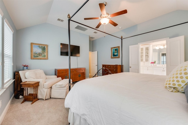 bedroom with ceiling fan, lofted ceiling, connected bathroom, and light carpet