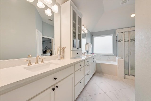 bathroom with vanity, vaulted ceiling, and separate shower and tub