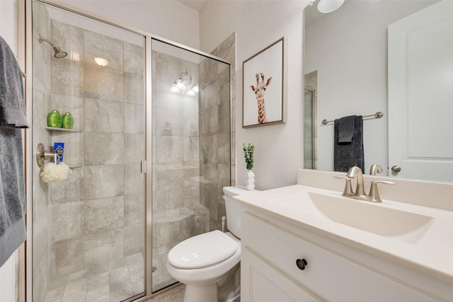 bathroom with a shower with door, vanity, and toilet