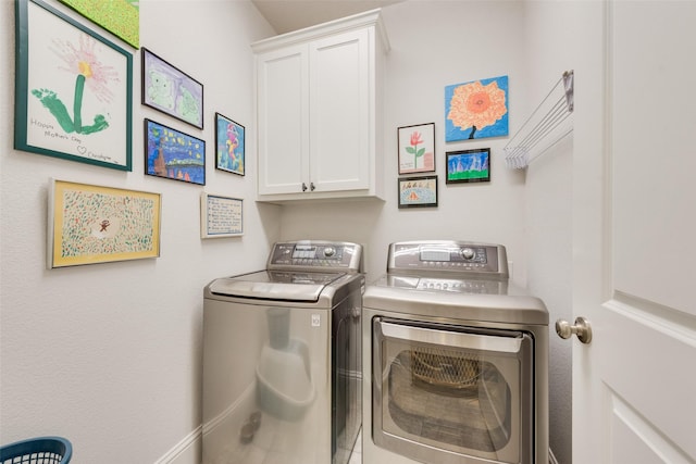 washroom with cabinets and washing machine and dryer