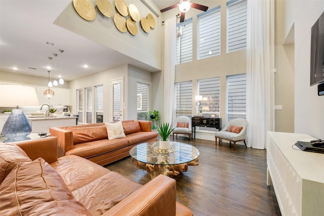 living room with plenty of natural light, dark wood-type flooring, sink, and ceiling fan