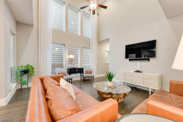 living room with a high ceiling, ceiling fan, and dark hardwood / wood-style flooring