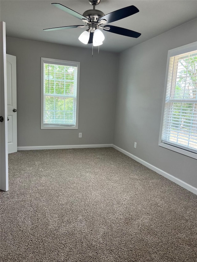 carpeted spare room featuring ceiling fan