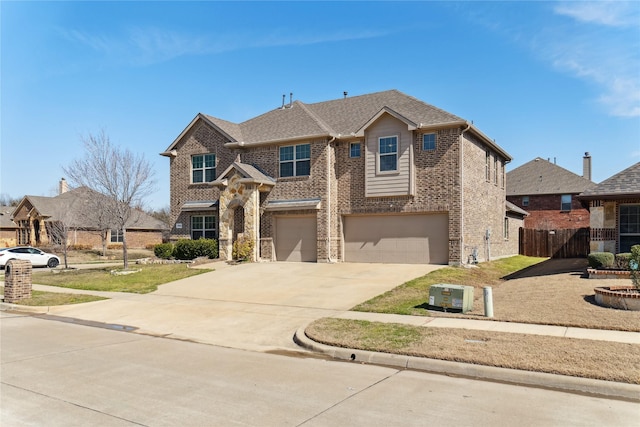 traditional home with brick siding, a shingled roof, an attached garage, fence, and driveway