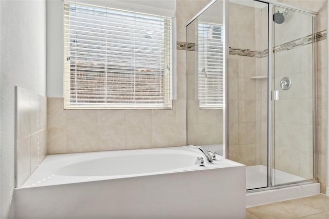 bathroom with a stall shower, a garden tub, and a healthy amount of sunlight