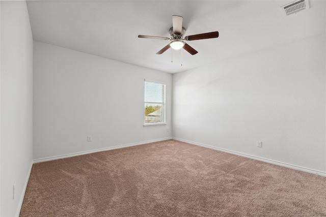 carpeted spare room with a ceiling fan, visible vents, and baseboards